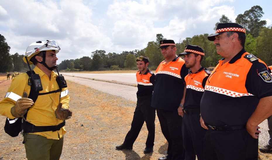 Miembros de Protección Civil atienden las indicaciones de un profesional del Infoca en una actuación de emergencia.